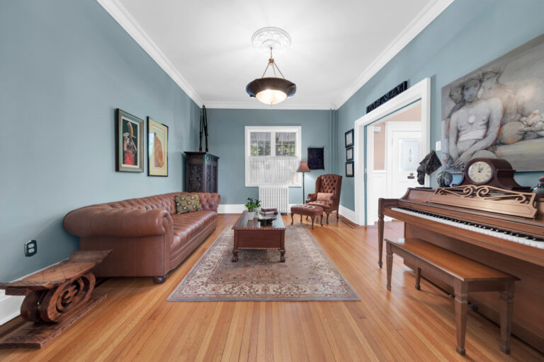 music room with piano and original wood pocket doors at 19 Occident Avenue in Stapleton Heights, Staten Island