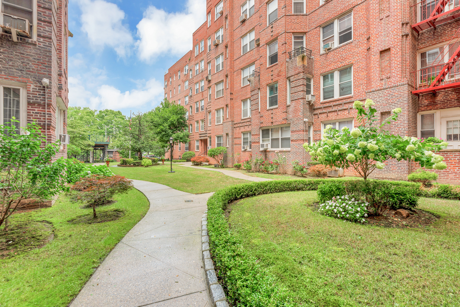 Brick prewar building exterior with landscaped courtyard at 8701 Shore Road prewar co-op Bay Ridge Brooklyn