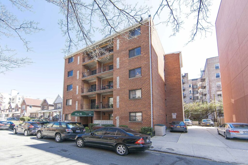 Front exterior of 26 Oliver Street, a five story red brick co-op in Bay Ridge, Brooklyn, with balconies on the upper floors.