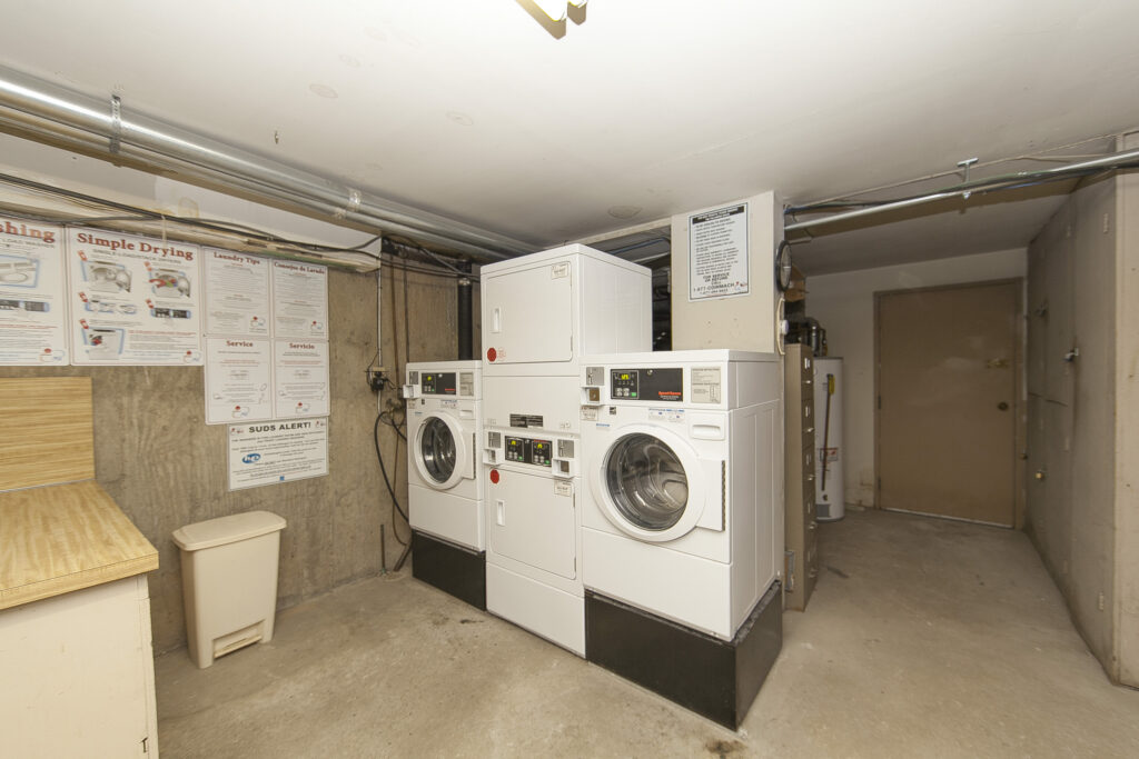 Shared laundry room at 26 Oliver Street with washers and dryers.