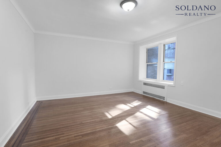 Living room with a pair of windows, crown moulding and oak floors at 9281 Shore Road Apt 122 in Bay Ridge, Brooklyn
