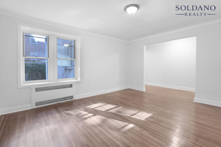 Living room with oak floors and a wide opening to the hall at 9281 Shore Road Apt 122 in Bay Ridge, Brooklyn